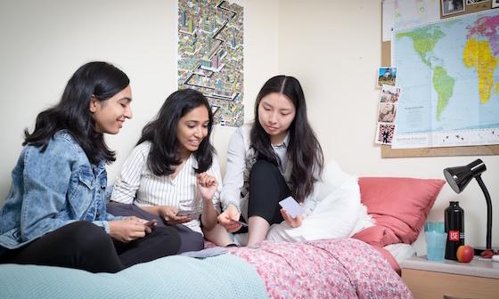 A group of students sat on a bed