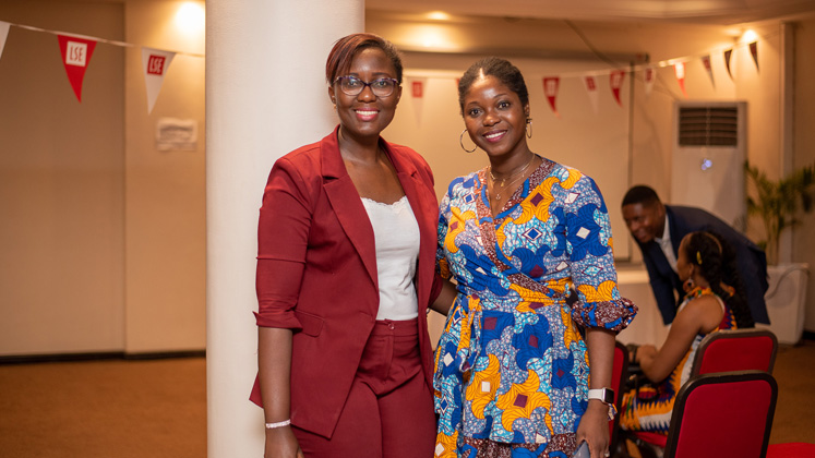 Two black women pose for a photo during an LSE alumni event